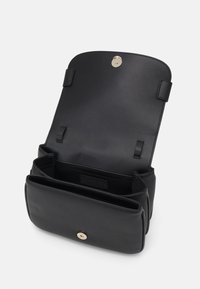 Borsa a mano in pelle nera con una texture liscia, chiusura a scatto magnetico e scomparti interni. Presenta un'etichetta con logo all'interno.