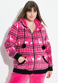 Felpa con zip in pile di un vivace colore rosa con motivi di renne e fiocchi di neve bianchi. Dettagli neri su polsini, tasche e lacci. Texture morbida.