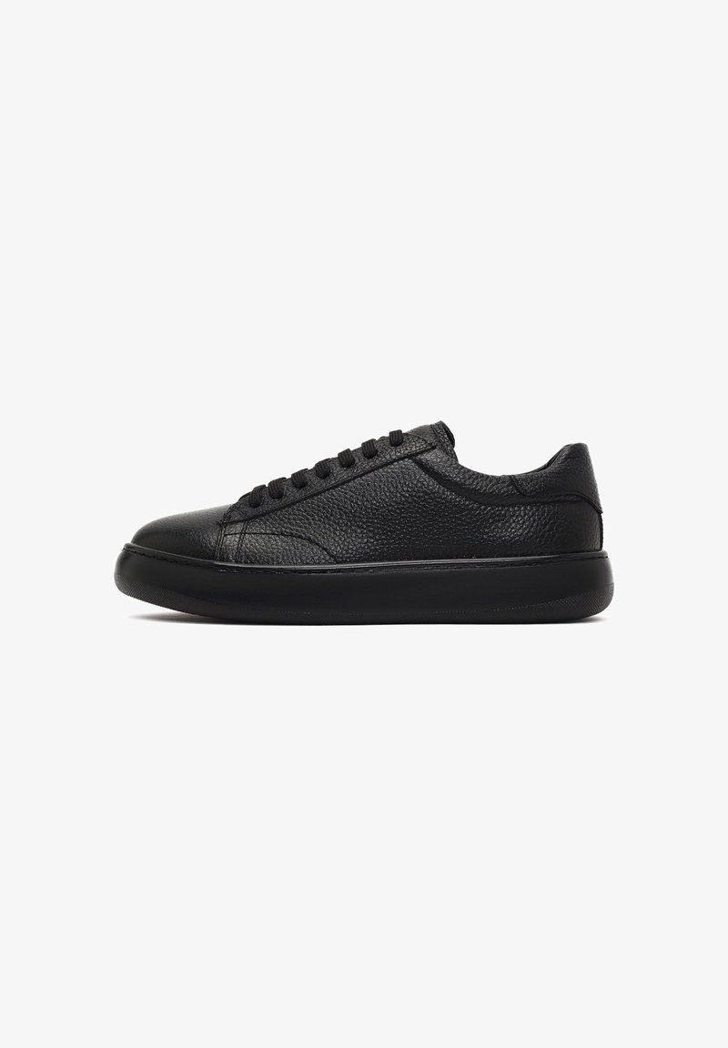 Czarne skórzane sneakersy o teksturowanej powierzchni, okrągłym nosku, płaskich sznurówkach, wyściółce kołnierza oraz solidnej gumowej podeszwie zapewniającej przyczepność.