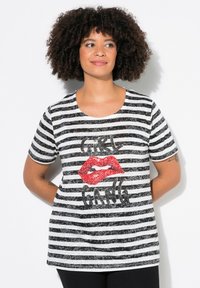 Camiseta de rayas blancas y negras con cuello redondo, que presenta un gráfico de labios de lentejuelas rojas y el texto "GIRL GANG" en purpurina negra.
