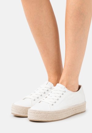 Baskets en toile blanche dotées d'une semelle épaisse tressée de style espadrille. Lacets et œillets assurent un maintien sécurisé. Design minimaliste aux lignes épurées.