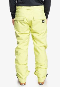 Hiihtohousut kirkkaassa keltaisessa, rento istuvuus, useita taskuja, vahvistetut saumat ja logopatch takana.