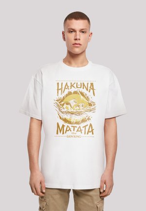 White cotton t-shirt featuring a gold graphic print with the text "HAKUNA MATATA" and a lion design, short sleeves, and a relaxed fit.