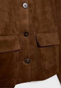 Brown suede jacket with large front button closures and two flap pockets at the waist.