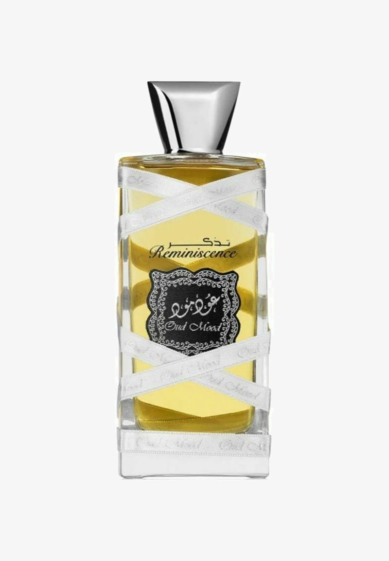 Glas parfume flaske med gul væske mærket "Reminiscence Oud Mood," indpakket i hvide bånd, med en skinnende sølvhætte.