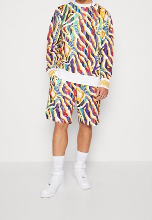 Sada mikiny a šortek v pestrých barvách s výraznými abstraktními vzory. Vyrobeno z lehké látky s bílými doplňky a manžetami.