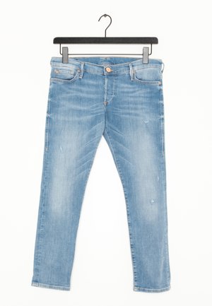 Jean en denim bleu clair avec un léger effet délavé et usé, suspendu sur un cintre noir sur fond blanc.
