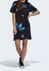 Svart t-shirtklänning med blå blommönster och tre-randiga detaljer. Tillverkad av ett mjukt tyg med en avslappnad passform och korta ärmar.
