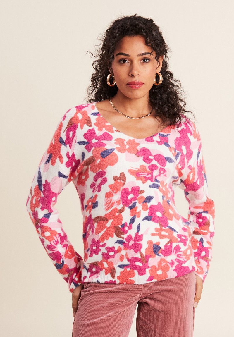 Blumenmuster-Pullover aus weichem, flauschigem Stoff mit weißem Grund, verziert mit rosa, roten und blauen Blumen. V-Ausschnitt und lange Ärmel.