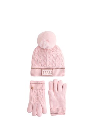 Bonnet rose tricoté avec un pompon en fourrure et des gants assortis. Présente un motif en torsades et une étiquette de marque brodée. Accents en or métallisé.