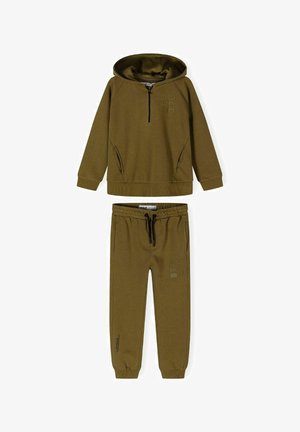Olivezöld kapucnis pulóver, félnyakkal és oldzsebekkel, párosítva hasonló színű, rajzos részlettel ellátott, húzózsinóros melegítőnadrággal.
