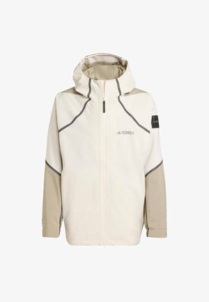 Lett, kremfarget jakke med glidelås foran, hette og grå detaljer. Har strukturerte ermer og en logo på brystet for merkevare.