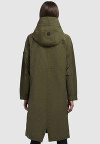 Manteau vert mi-long avec une capuche, orné d'un détail de bouton noir à l'arrière, et d'une coupe droite avec des ouvertures sur les côtés. Texture de tissu lisse.