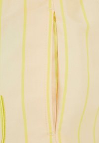 Tissu rayé rose et jaune avec une fermeture éclair dissimulée. Le matériau semble lisse avec un léger éclat, et les coutures sont bien finies.
