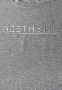 Grijze katoenen sweatshirt met reliëftekst "AESTHETIC SMOOTH GREYS OF COLOR," ronde halslijn en een zachte, gladde textuur.