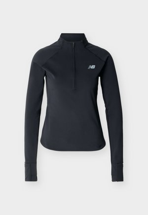 Μαύρο αθλητικό τοπ με μακριά μανίκια, μπροστινό φερμουάρ έως τη μέση, οπές για τους αντίχειρες στα μανίκια και το λογότυπο της New Balance στο αριστερό μέρος του στήθους.
