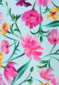 Tissu floral avec des fleurs roses vives, jaunes et violettes sur un fond bleu clair, avec des feuilles vertes et un petit logo doré.