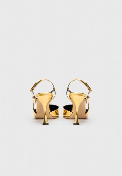 Sandales à talons hauts dorées avec un dos ouvert, une bride de cheville et un fin talon aiguille. Fini métallique lisse avec une doublure intérieure noire.
