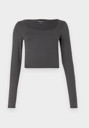 Langærmet, cropped top i mørkegrå, lavet af blødt stof. Har en bred halsudskæring og tætsiddende design, uden synlige mønstre eller detaljer.