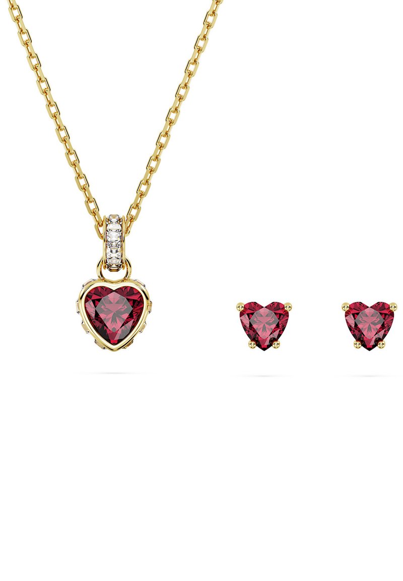 Goldkette mit einem herzförmigen roten Edelstein-Anhänger und kleinen passenden Herz-Ohrsteckern. Goldene Kettenglieder mit zusätzlichen weißen Steinen.