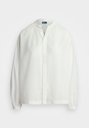 Bela bombažna srajca z okroglim izrezom, dolgimi rokavi, gatheranim pri manšetah, z gumbom in sproščenim krojem. Gladka tekstura, minimalistična zasnova.