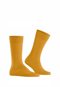 Chaussettes en coton jaunes avec des bordures côtelées. Texture lisse, forme standard avec un orteil fermé. Pas de motifs ni d'accents supplémentaires.