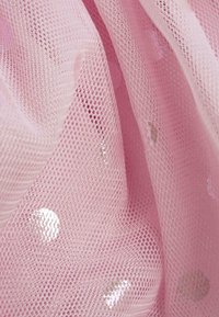 Tessuto a rete rosa con una superficie morbida e testurizzata, caratterizzato da motivi a pois riflettenti sparsi in tutto il design. Struttura leggera e trasparente.