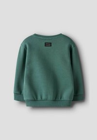 Zielony sweter z okrągłym dekoltem, z prążkowanymi rękawami i dolnym brzegiem, z małą czarną metką z białym tekstem umieszczoną na środku poniżej tylniego dekoltu.