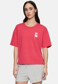Rød bomulds t-shirt med rund hals og korte �ærmer, prydet med et hvidt logo på venstre bryst. Casual fit, glat tekstur.