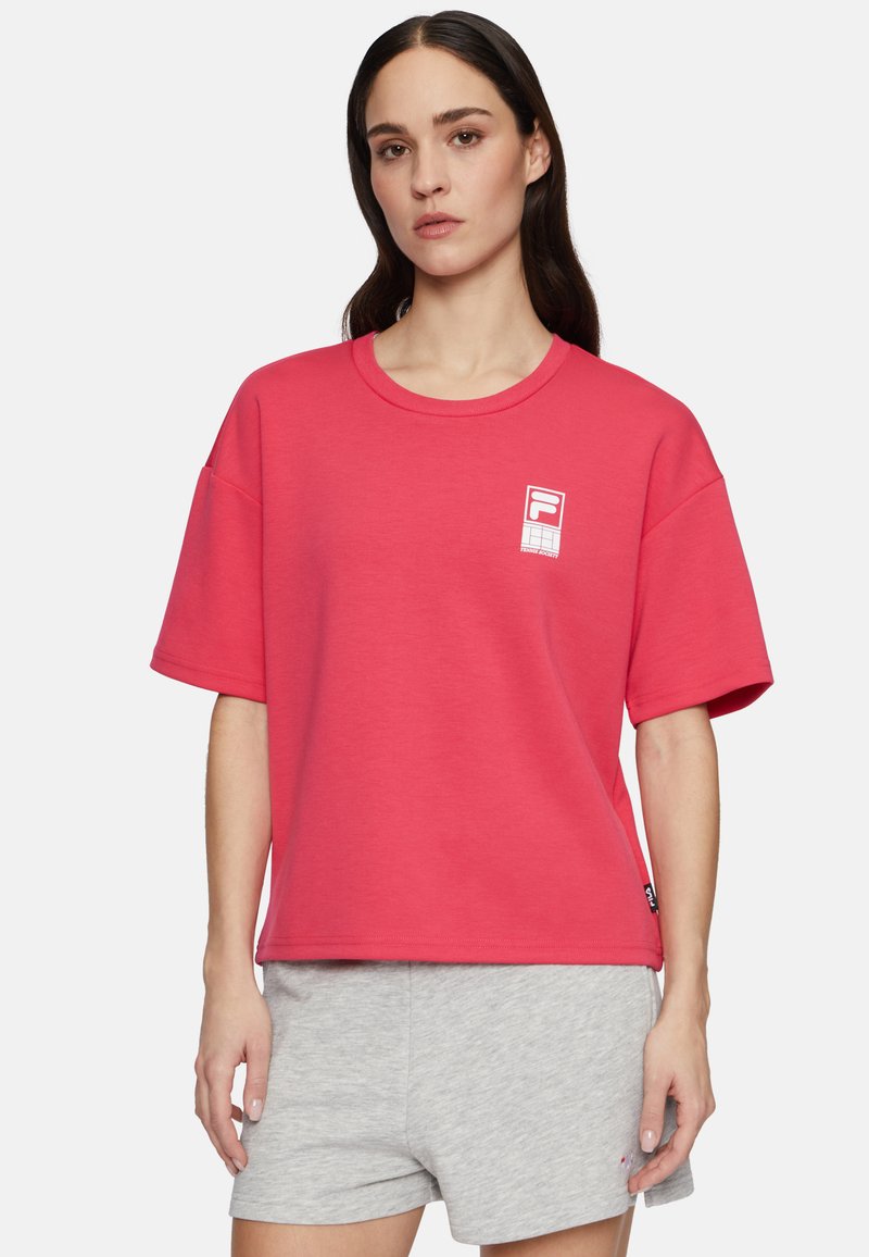 Rød bomulds t-shirt med rund hals og korte ærmer, prydet med et hvidt logo på venstre bryst. Casual fit, glat tekstur.