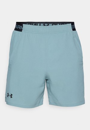 Lyseblå sportsbukser med elastisk talje, der har sort branding. Inkluderer sidelommer og et strømlinet design.