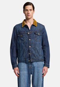 Giubbotto di jeans scuro con colletto in corduroy giallo, tasche anteriori e bottoni metallici. Design classico con vestibilità rilassata e texture in denim blu.