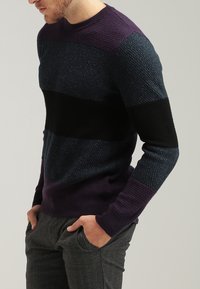 Sweter robiony na drutach z kolorowym wzorem w odcieniach ciemnoniebieskim, purpurowym i czarnym, z fakturowanymi wzorami i okrągłym dekoltem.