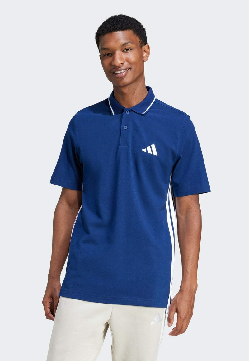 Marineblauw poloshirt met witte accenten, met een knoopsluiting op de kraag en een driekleurig logo ontwerp op de borst, gemaakt van een soepele, ademende stof.