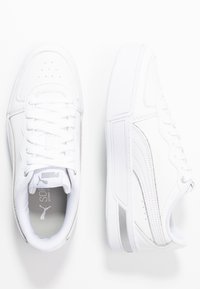 Bílé sportovní tenisky s texturovaným koženým svrškem, kulatou špičkou, šněrováním, jemnými stříbrnými akcenty a gumovými podrážkami.