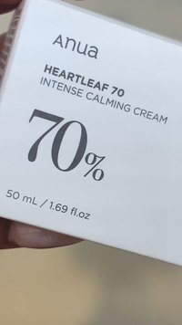 Emballage de la crème apaisante intense Anua Heartleaf 70 montrant une concentration de 70 % et un volume de 50 mL / 1,69 fl. oz, tenue par une main.