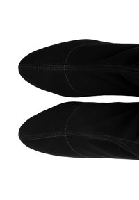 Stivali alla caviglia in suede nero con punta affilata e dettagli cuciti. Texture liscia e design aderente intorno alle caviglie.