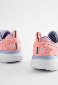Vue arrière de chaussures de sport présentant un dessus synthétique rose, des accents violets, une languette noire rayée et une semelle extérieure texturée blanche.