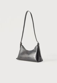 Μαύρο δερμάτινο τσάντα ώμου με εκτύπωση κροκοδείλου, με μία μοναδική κλείσιμο με φερμουάρ και μακριά λεπτή λουράκι, πάνω σε απλό λευκό φόντο.