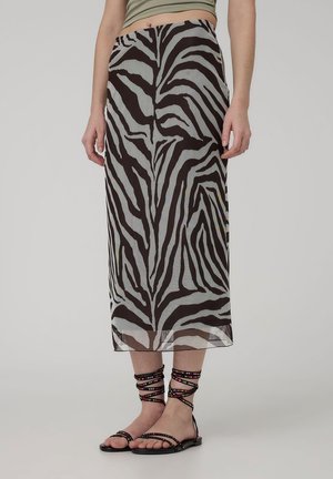 Gonna trasparente nera e beige con una stampa zebra audace, design a lunghezza media, con texture stratificata, abbinata a sandali piatti e con cinturini.