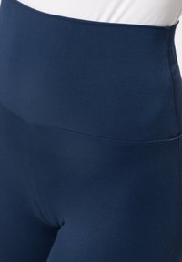 Leggings de tiro alto en color marino, confeccionados con una tela elástica de textura suave y diseño ajustado, que presentan un acabado limpio y sin costuras.