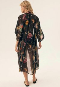 Przezroczysty czarny kimono z kolorowymi, kwiatowymi i motylkowymi wzorami, z luźnymi rękawami i średnią długością.
