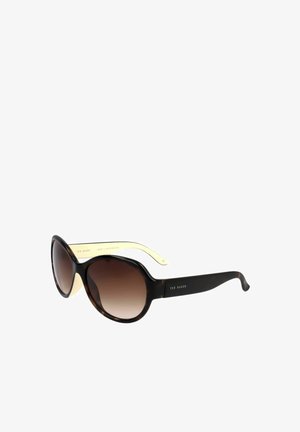 Occhiali da sole rotondi oversize con lenti sfumate marrone scuro e montatura scura in tartaruga con aste interne giallo pallido.