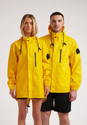 Yellow waterproof jackets with adjustable hoods, zippered pockets, elastic cuffs, and contrasting black accents. Designed for unisex wear.