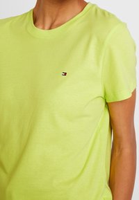 Lysegrønt bomulds T-shirt med rund hals, korte ærmer og et lille, multicolor logo på venstre bryst. Blød tekstur.