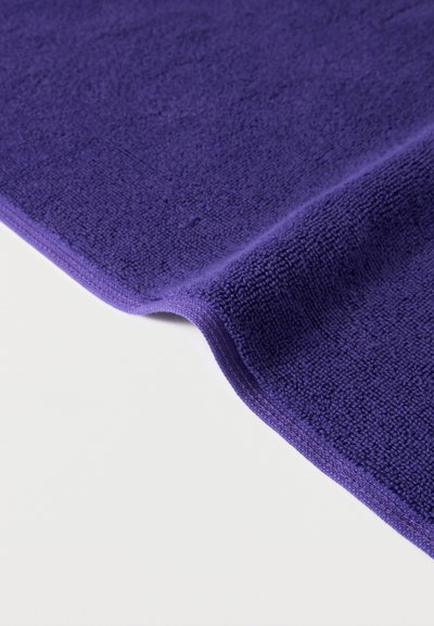 Διπλωμένο μωβ πανί καθαρισμού από μικροΐνες με υφή σε λευκό φόντο.