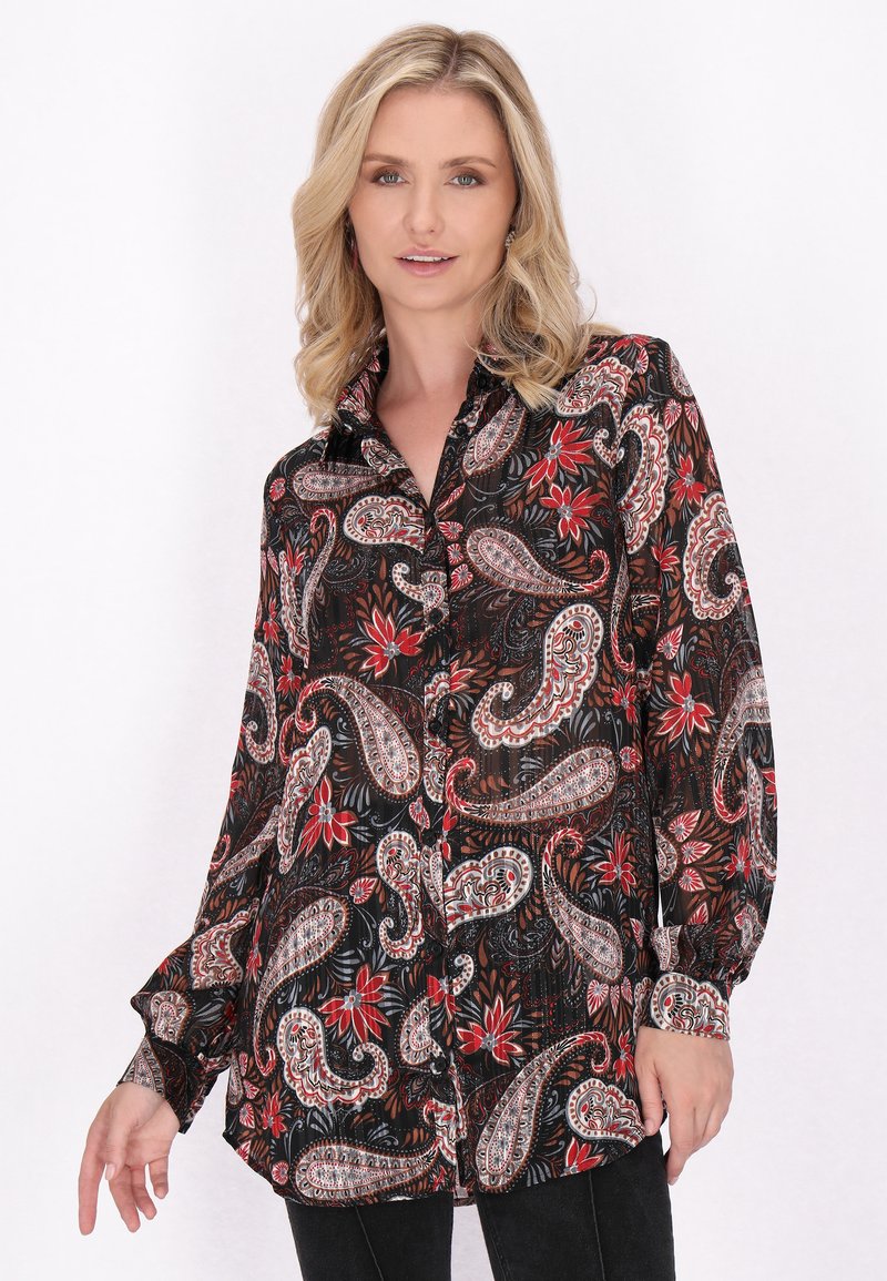 Camicetta nera con bottoni decorata con motivi paisley e floreali in rosso, bianco e grigio. Presenta maniche lunghe e un taglio rilassato.