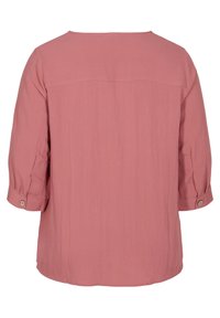 T-shirt ample à manches trois-quarts en rose poussiéreux, avec un col rond et des accents de boutons sur les manches. Tissu doux et texturé.