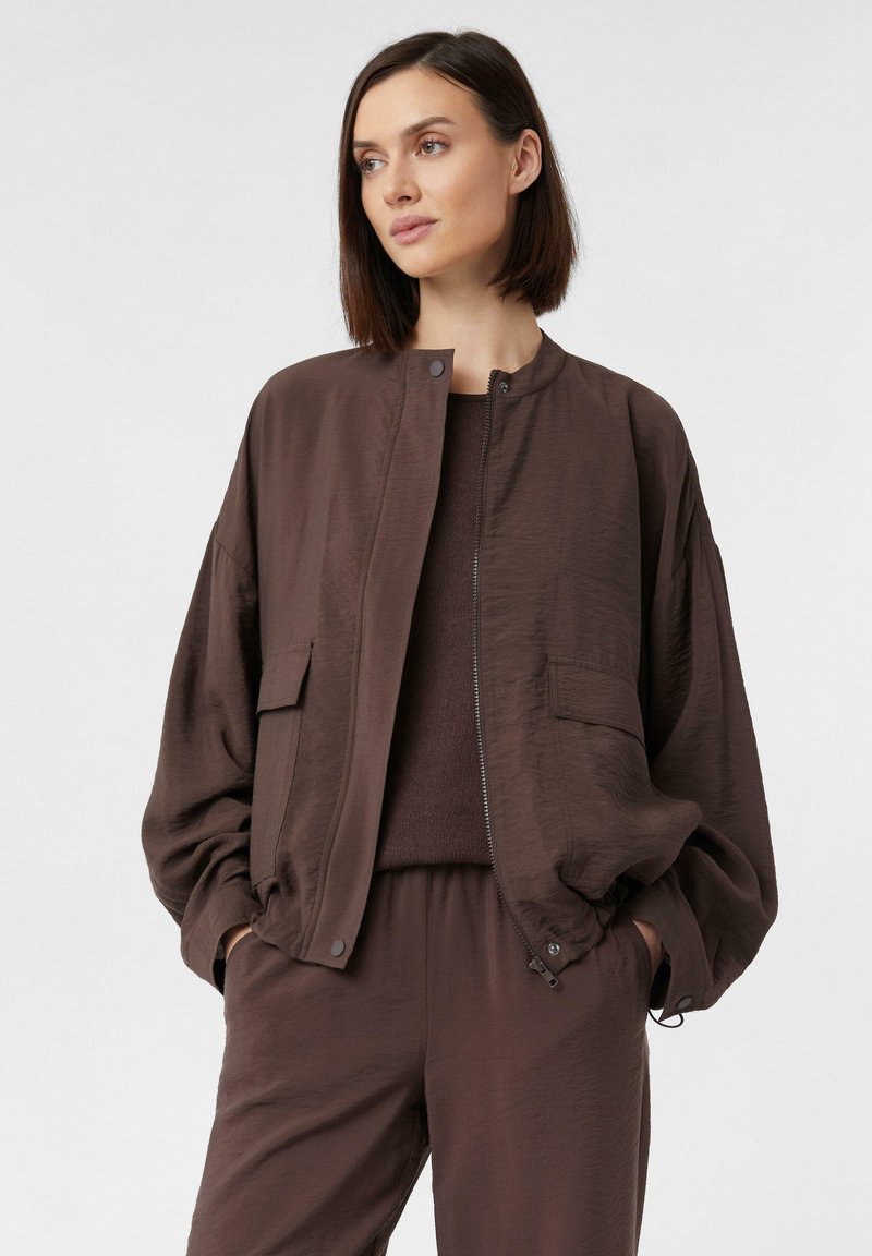 Braune Bomberjacke mit einer glatten, leicht strukturierten Oberfläche, mit einem Reißverschluss, seitlichen Taschen und einer lässigen Silhouette.