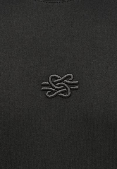 Black sweatshirt with a textured, dark grey embroidered logo on the chest. The fabric appears smooth and is free of patterns.